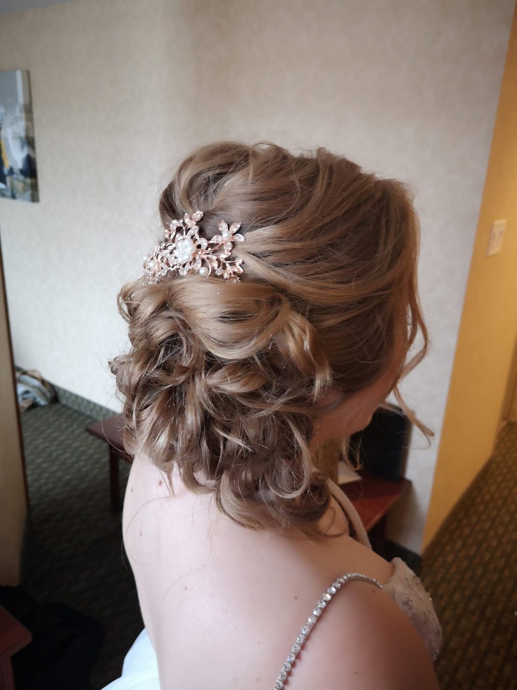 Curled bridal updo finished with a pearl hair comb
