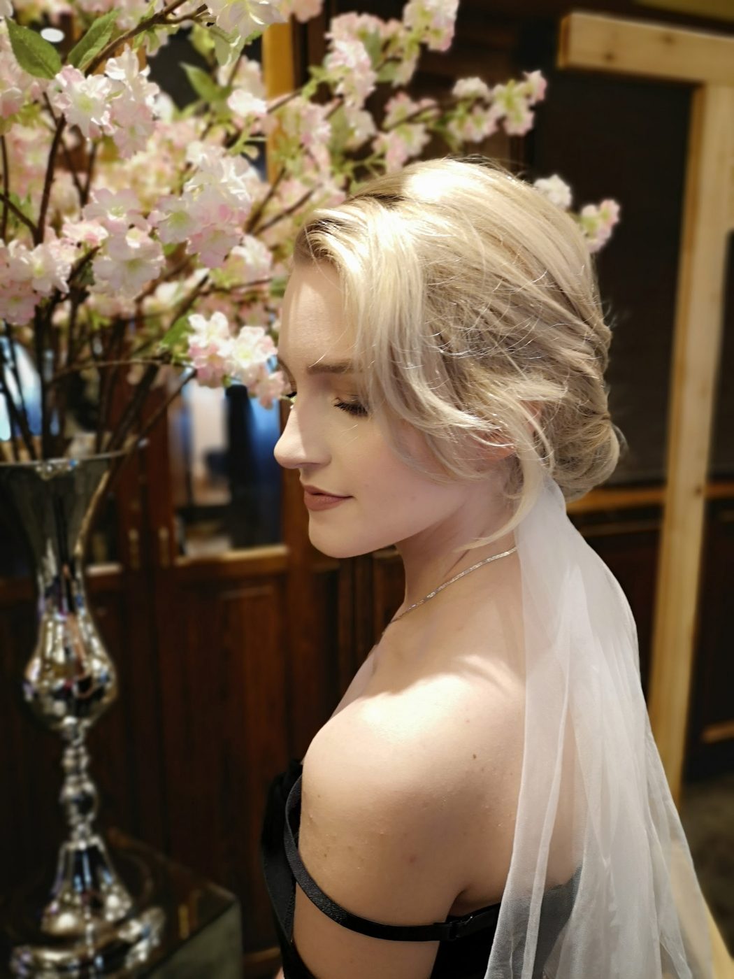 Bridal updo with loose face-framing pieces and a veil