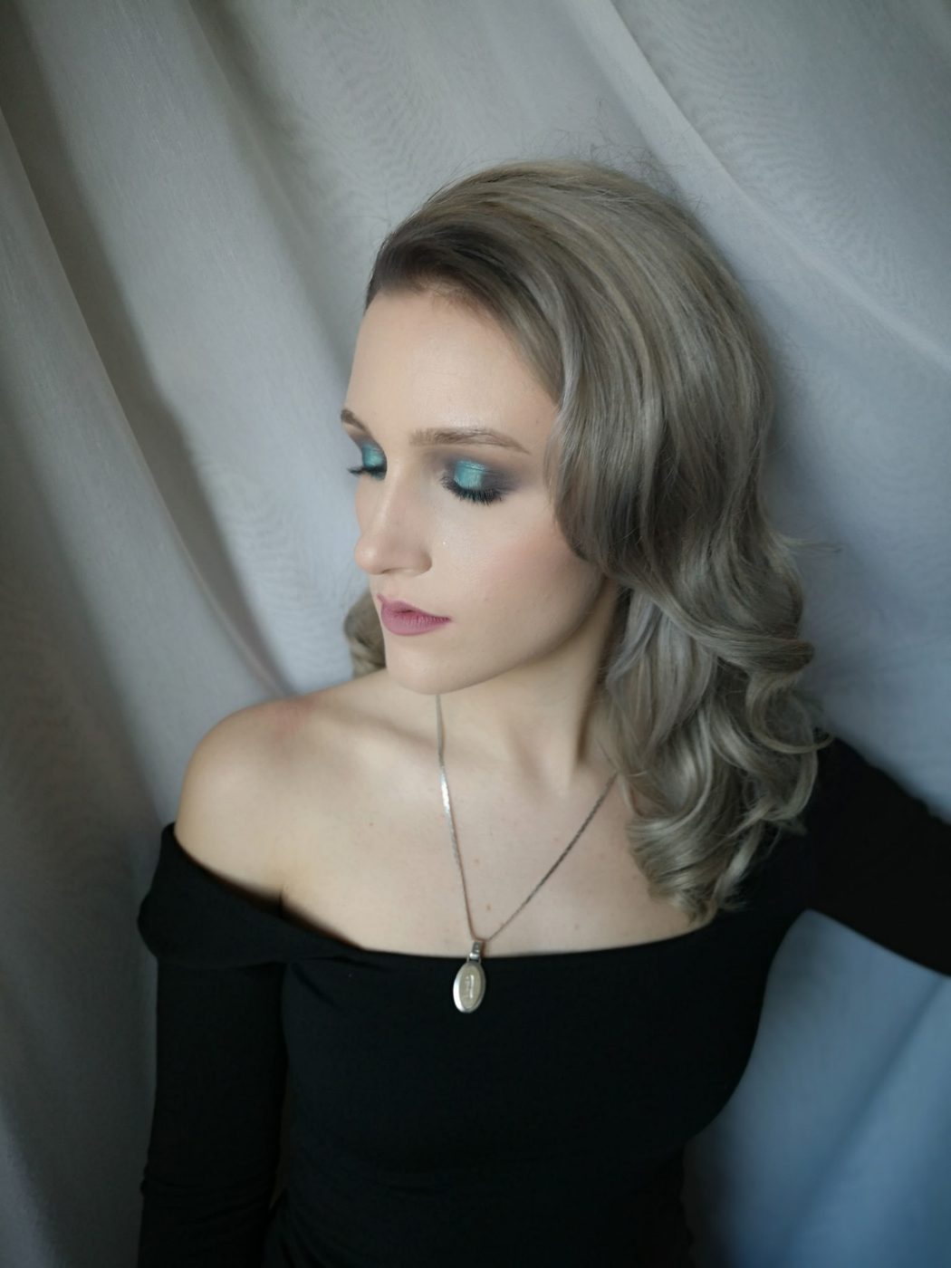 Silver-blonde hair styled in glossy vintage waves